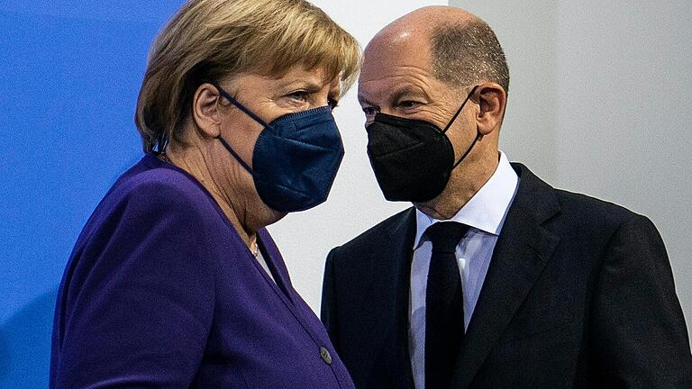 Die geschäftsführende Bundeskanzlerin Angela Merkel (CDU) und Olaf Scholz (SPD), designierter neuer Kanzler, nach der Ministerpräsidentenkonferenz zur Corona-Pandemie.