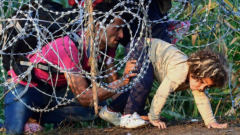 Ein kleines Mädchen und sein Vater versuchen, den provisorischen Grenzzaun zwischen Serbien und Ungarn zu überwinden, um in die EU zu gelangen.
