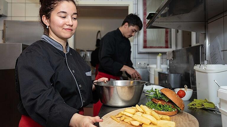 Azubi Days im Fränkischen Hof Marktbreit       -  Die Auszubildenden des „Fränkischen Hofs“ in Marktbreit, Leandro Gebhardt und Farangis Haqnazarova, haben eine Platte mit Burger und Pommes garniert. Fotos: Patty Varasano