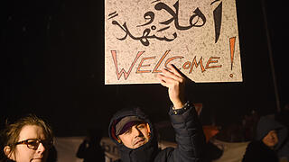 Solidaritätskundgebung für Flüchtlinge in Clausnitz       -  Der Kontrast: 'Welcome; steht auf einem Poster, das Teilnehmer am 20.02.2016 zu einer Solidaritätskundgebung nahe der Flüchtlingsunterkunft in Clausnitz, einem Ortsteil von Rechenberg-Bienenmühle (Sachsen), mitgebracht haben. Nach den fremdenfeindlichen Protesten am 18. Februar in Clausnitz soll ein friedliches Zeichen gegen Gewalt und Rassismus in Sachsen gesetzt und gegen das Vorgehen der Polizei protestiert werden.