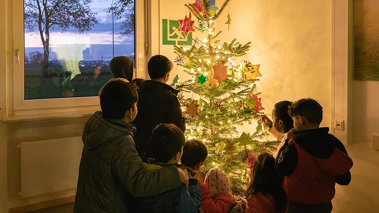 Gemeinsam schmücken die Kinder in der Anker-Einrichtung den Christbaum im Ärztezentrum mit Sternen und Weihnachtsbäumchen, die sie im Kinderhaus mit ihren Erzieherinnen gebastelt haben.