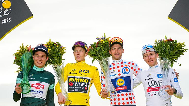 Tour de France 2023.jpeg       -  Jonas Vingegaard (2.v.l), Jasper Philipsen (l), Giulio Ciccone (2.v.r) und Tadej Pogacar feiern auf dem Podium.
