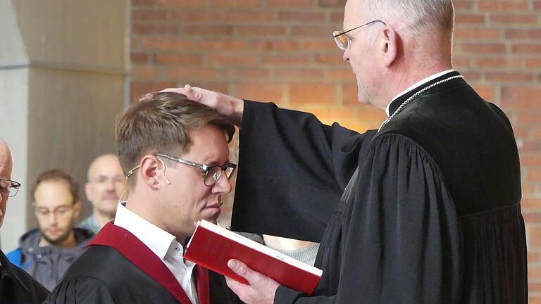 Dekan Oliver Bruckmann segnet Johannes Michalik. Er übernimmt die Pfarrstelle in der Schweinfurter Auferstehungskirche.