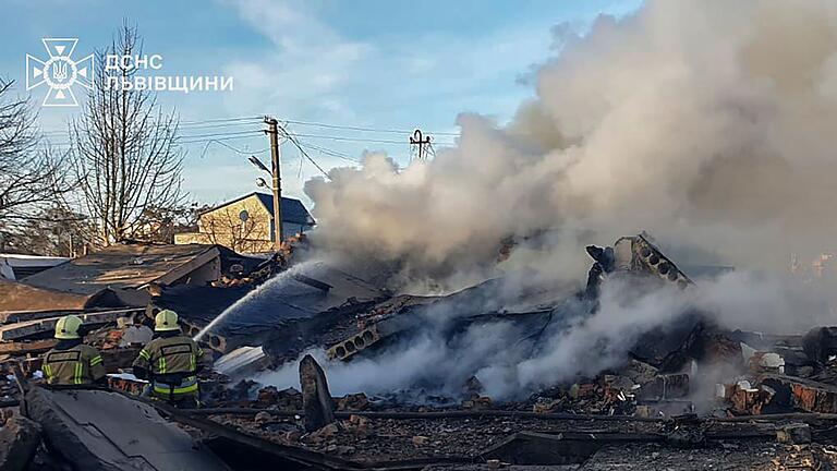 Ukraine-Krieg - Lwiw       -  Feuerwehrleute löschen einen Brand in Lwiw nach einem russischen Raketenangriff.