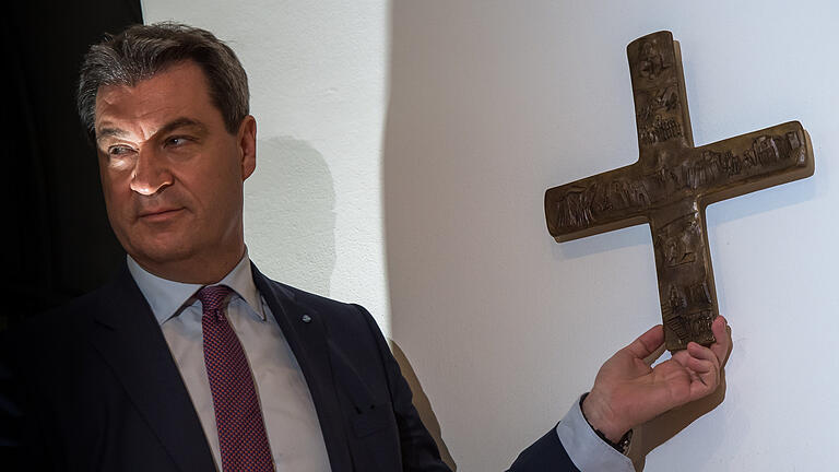 Sitzung Kabinett       -  Markus Söder, Bayerischer Ministerpräsident (CSU), hängt ein Kreuz im Eingangsbereich der bayerischen Staatskanzlei auf.