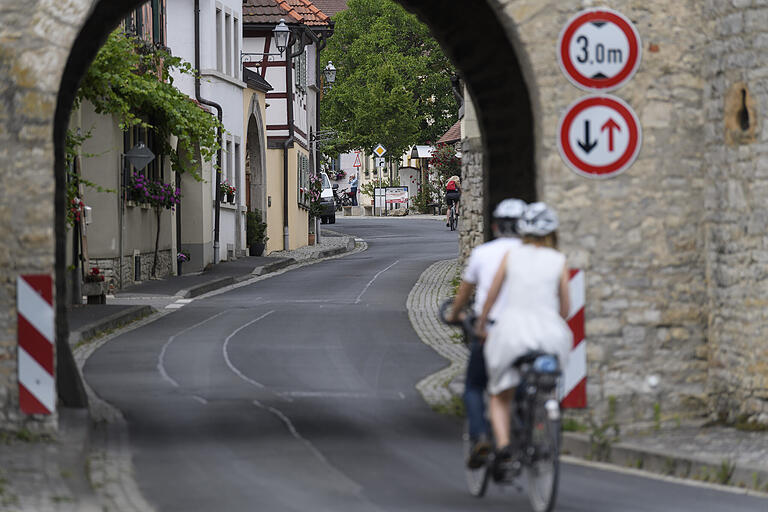 Zwei Radfahrer durchqueren den Torbogen am Ortseingang von Sommerach. Aufgrund der Corona-Pandemie zieht es in diesem Jahr besonders viele Gäste an die Mainschleife. Zwei Radfahrer durchqueren den Torbogen am Ortseingang von Sommerach. Aufgrund der Corona-Pandemie zieht es in diesem Jahr besonders viele Gäste an die Mainschleife.