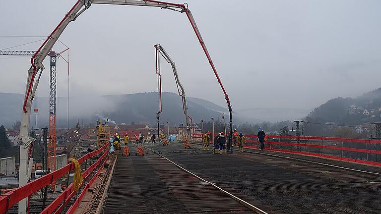 Mit zwei Betonpumpen füllten 15 Arbeiter am Mittwoch die Verschalung über der Bahnlinie, das erste Stück der neuen Gemündener Mainbrücke.