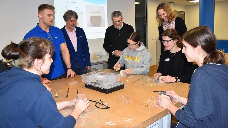 Schleifpapier statt Schulheft. In der Wissenswerkstatt in Schweinfurt bastelten die Mädchen am Dienstag unter Anleitung von Kevin Fischer (hinten links) an einer LED-Lampe.&nbsp;Dabei schauen ihnen von links Schulleiter Klemens Alfen, Erwin Siebert (MINT-Beauftragter der Bundesagentur für Arbeit in Bayern) und Sabine Sigloch, Projektbetreuerin am Alexander-von-Humboldt-Gymnasium, über die Schulter.