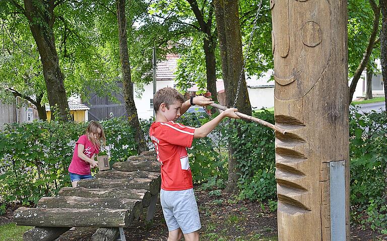 Während Silas am Spielplatz in Alsleben verschiedene Töne dem großen Holzstamm entlockt ist seine Schwester Elias mit dem großen Hammer beschäftigt, um damit das Holzxylofon zu testen.