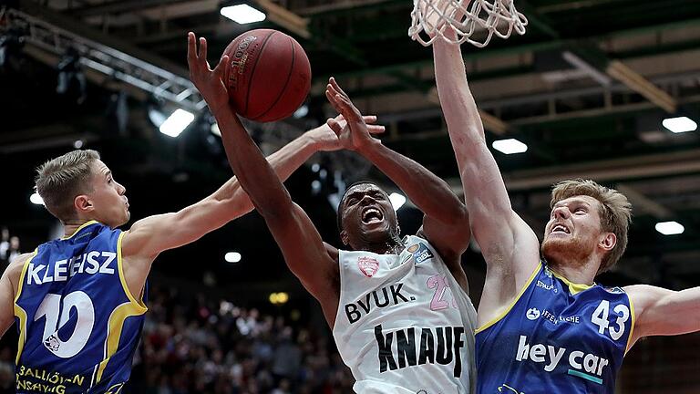 Basketball - easyCredit BBL - s.Oliver Wuerzburg - Basketball Loewen Braunschweig       -  Hart umkämpfte Partie: Würzburgs Cameron Wells (Mitte) im Dreikampf mit den Braunschweigern Thomas Klepeisz (links) und dem überragenden Scott Eatherton.