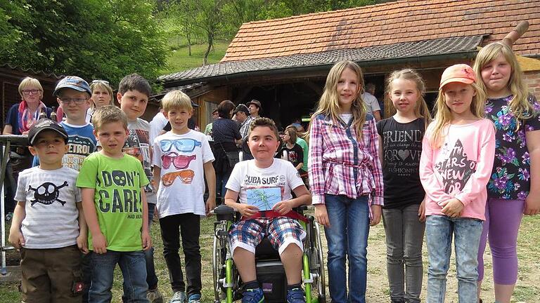 Kinder spenden für Rollstuhlfahrer       -  (gi)   Einer schönen Tradition folgend haben die elf Retzstadter Kommunionkinder einen Teil ihrer Geschenke weitergeschenkt. Der 16-jährige Moritz Urlaub ist aufgrund einer fortschreitenden Muskelerkrankung auf einen elektrischen Rollstuhl angewiesen. Für den Kauf eines behindertengerechten Autos mit Rampe hatten Freunde und Bekannte ein kleines Grillfest bei den Retztal-Lamas organisiert, in dessen Verlauf die Kinder 100 Euro übergaben. Weitere 80 Euro kommen der Elterninitiative leukämie- und tumorkranker Kinder Würzburg zugute. Schließlich pflanzten die Kommunionkinder zusammen mit der Kirchenverwaltung zwei Zierkirschen und zwei Weiden an der Kreuzkapelle und übernahmen die Kosten für einen Baum in Höhe von 150 Euro gemäß ihres Gottesdienstmottos &bdquo;Wir sind alle Früchte in Gottes Garten&ldquo;.