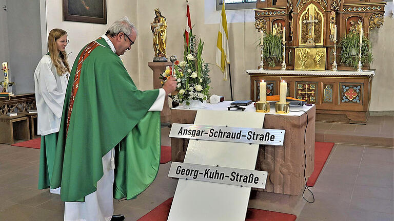 Pfarrer Helmut Rügamer segnet in der Martinskirche Burggrumbach die neuen Straßenschilder.