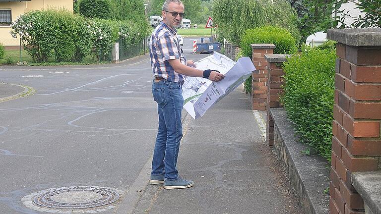 Bürgermeister Andreas Hoßmann überprüft die Lage der Kanäle in Eisenheim anhand von Bebauungsplänen.