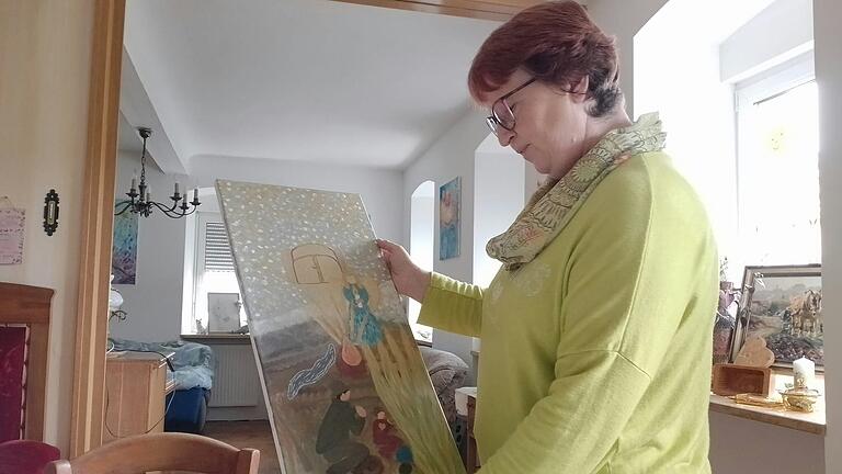 Veronika Fleischmann in ihrem Wohnzimmer in Gützingen, mit dem Bild, das sie anlässlich des Kriegsgedichts ihres Großvaters gemalt hat.&nbsp;