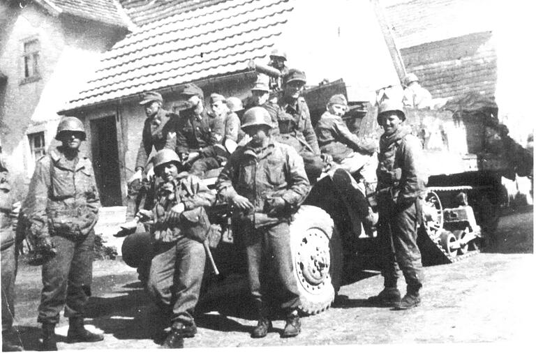 Ein Erinnerungsfoto aus dem Archiv der 12. US-Panzerdivision zeigt Soldaten eines Infanterie-Bataillons der 12. US-Panzerdivision mit deutschen Kriegsgefangenen.