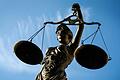 Eine Statue der römischen Göttin Justitia mit einer Waage symbolisiert Gerechtigkeit und Rechtswesen.