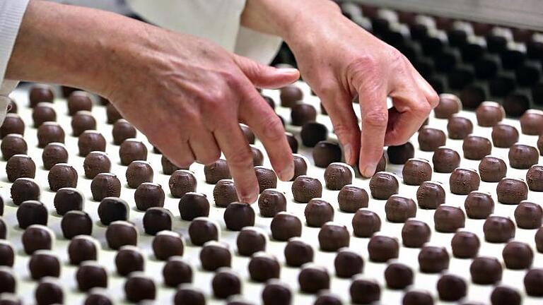 Kalorienhaltiges Muster: Eine Mitarbeiterin überwacht in Deutschlands ältester Schokoladenfabrik, der Halloren Schokoladenfabrik AG in Halle/Saale, die Produktion. Foto: Jan Woitas       -  Die Schokoladenfabrik, in der die bekannte Mozartkugel hergestellt wird, schließt in Folge der Firmeninsolvenz.