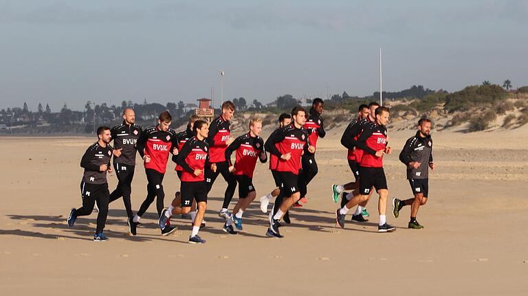 Kapitän Sebastian Schuppan läuft an der Seite von Trainer Michel Schiele beim Strandlauf vorneweg.