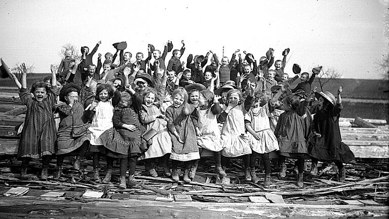 Fotografiert von Josef Murr vor 100 Jahren mit der Plattenkamera: Vermutlich die jüngeren Schulkinder von Goßmannsdorf (Lkr. Würzburg) bei einem Ausflug an die Tauber. Das Bild wurde auf dem Holzplatz auf einem Stapel Floßholz aufgenommen.