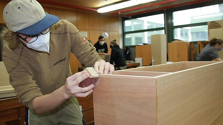 Florian Weigel feilt in der Berufsschule Kitzingen an seinem Werkstück. Auch die Schreinerbranche macht sich Sorgen um genügend Nachwuchs. Fotos: Ralf Dieter