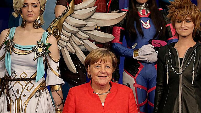 Eröffnung  Gamescom       -  Bundeskanzlerin Angela Merkel eröffnete die Computerspielemesse Gamescom in Köln. Das Bild zeigt die Kanzlerin mit Cosplayern.