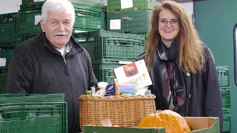 Manfred Seigner freut sich über die Spende von Birgit Firsching – für dieses Foto hat sie sogar einen zweiten Korb gepackt. Für die Helferinnen und Helfer der Tafel Kitzingen war ein Päckchen Merci dabei.