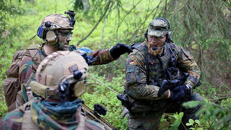 Ein Soldat des deutschen Kontingentes bei einer Übung in Litauen. Links zwei litauische Soldaten.&nbsp;