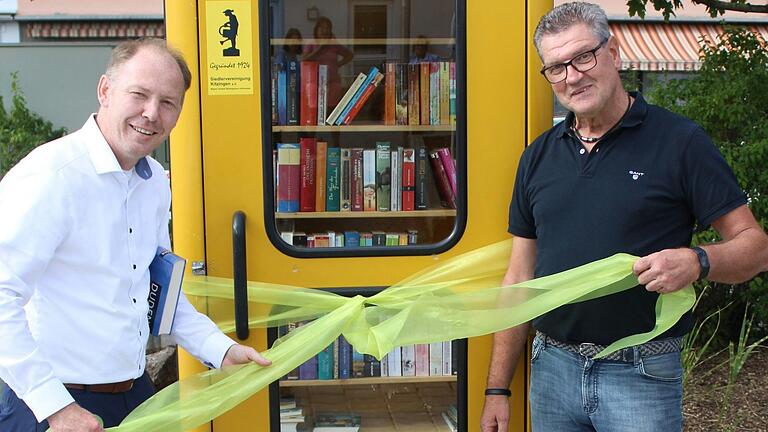 Oberbürgermeister Stefan Güntner und Ralf Machwart bei der offiziellen Einweihung der neuen „Bücherzelle“ in der Kitzinger Siedlung.