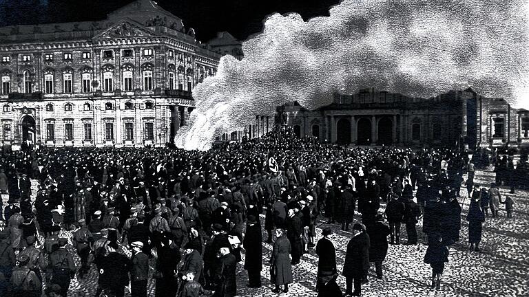 Auf dem Residenzplatz: Die Würzburger Studentenschaft verbrannte am 10. Mai 1933 sogenannte &bdquo;Zersetzungs- und Schundliteratur&ldquo;. Weil wohl am Abend keine verwendbaren Fotos entstanden, kopierte man später in das Bild einer anderen Menschenmenge vor der Residenz eine Rauchfahne und einen dunklen Himmel.