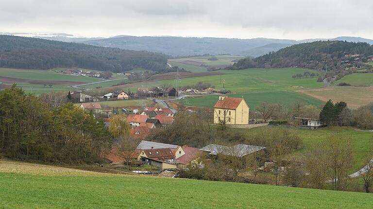 Blick über Oberwaldbehrungen bis auf die verschneiten Kuppen der Rhön