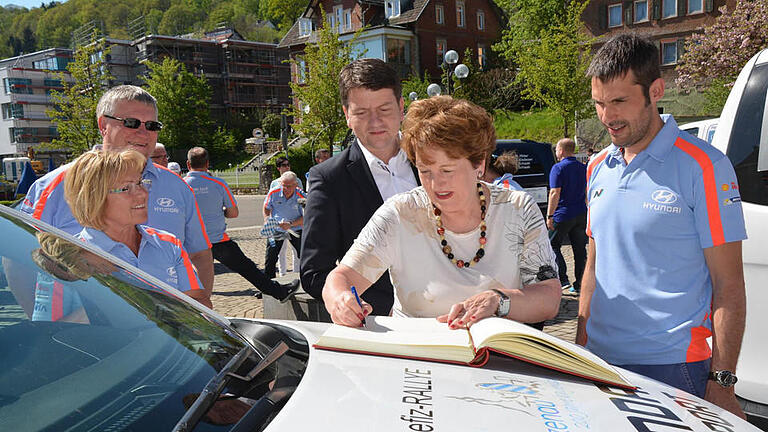 Bad Brückenaus Bürgermeisterin Brigitte Meyerdierks trug sich in das Rallye-Buch ein. Der Rathauschefin über die Schulter schaut MdL Sandro Kirchner.  Foto: Stadt Alzenau       -  Bad Brückenaus Bürgermeisterin Brigitte Meyerdierks trug sich in das Rallye-Buch ein. Der Rathauschefin über die Schulter schaut MdL Sandro Kirchner.  Foto: Stadt Alzenau