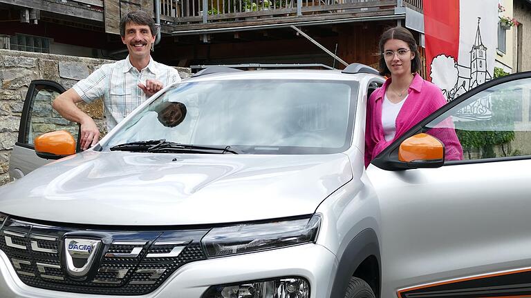 Familie Reuß aus Halsheim – zu sehen sind Vater Edwin und Tochter Antonia – teilt sich zu dritt einen elektrischen Dacia für Fahrten zur Arbeit und Universität in Würzburg.