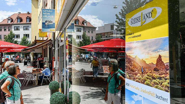 Passanten schauen sich die Angebote im Schaufenster eines Würzburger Reisebüros an. Griechenland als Urlaubsziel steht auch bei den Würzburgern wieder hoch im Kurs.