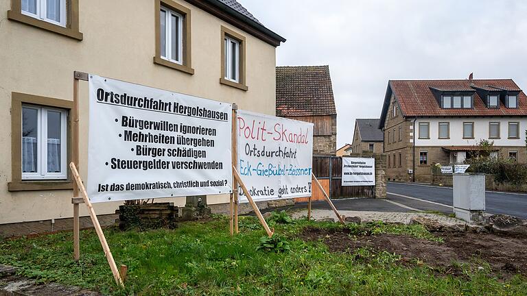 Mit großen Bannern und Plakaten protestieren Anwohnerinnen und Anwohner in Hergolshausen gegen die Teilverlegung der Durchfahrtsstraße. Sie soll künftig an ihren Wohnhäusern vorbeiführen. Mit großen Bannern und Plakaten protestieren Anwohnerinnen und Anwohner in Hergolshausen gegen die Teilverlegung der Durchfahrtsstraße. Sie soll künftig an ihren Wohnhäusern vorbeiführen.