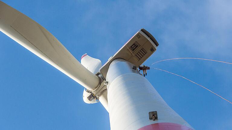 Arbeitseinsatz in 139 Metern Höhe: Stück für Stück seilt sich ein Industriekletterer ab und säubert per Hand den ölverschmierten Turm der Master-Windkraftanlage im Windpark Obbach.