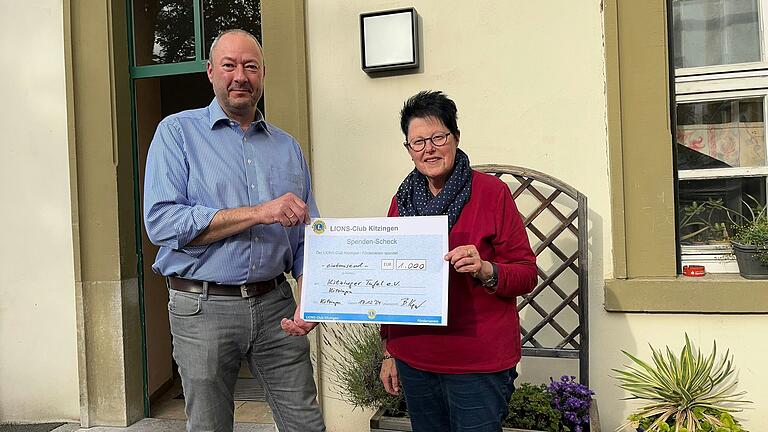 Katharina Müller, 1. Vorsitzende der Tafel Kitzingen, freut sich über die Spende vom Lions-Club Kitzingen, übergeben von dessen Vizepräsident Björn Keyser.