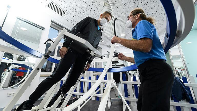 Ins Gleichgewicht kommen über Füße, Knie und Hüfte: In der Rehaklinik am Kurpark in Bad Kissingen probiert Krebspatient Rolf Schnitzler (links) angeleitet von Therapeut Steffen Wentrock den 3D-Stabilisator aus.&nbsp;