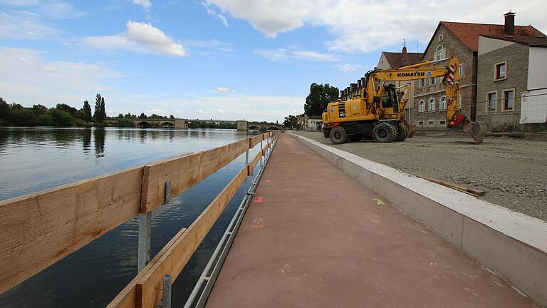 Die Baustelle am Oberen Mainkai in Kitzingen während der Baupause im August. Der neue Steg ist zum Arbeitsschutz noch vorläufig durch ein Holzgeländer gesichert. Die Baustelle am Oberen Mainkai in Kitzingen während der Baupause im August. Der neue Steg ist zum Arbeitsschutz noch vorläufig durch ein Holzgeländer gesichert. 