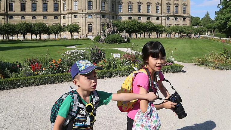 Wer darf das Denkmal fotografieren? Diese beiden Kinder aus Japan streiten sich im Hofgarten der Residenz um die Kamera.