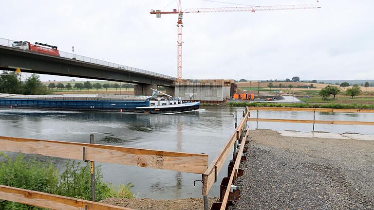 Zur Montage der Behelfsbrücke neben der bestehenden Mainbrücke bei Horhausen wurden eigens (rechts) zwei Anlegestellen am Mainufer errichtet. Dort machen die Pontons fest, mit deren Hilfe der an Land dann fertig montierte Stahlbogen im November dieses Jahres auf die Behelfsbrückenpfeiler (im Hintergrund der nördliche Pfeiler) geschoben wird.