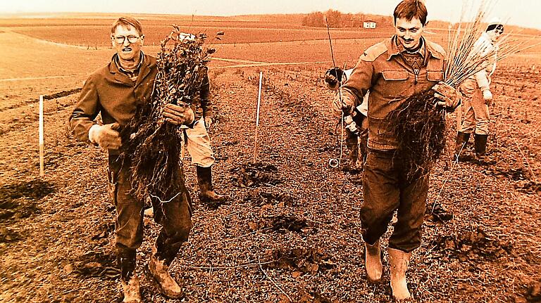 Vor 25 Jahren: Erwin Edelmann und Bauhofleiter Walter Zeißner pflanzen Setzlinge auf der kargen Fläche 'Am Galgenberg'; im Hintergrund der Aussiedler 'Felsenhof'. Vor 25 Jahren: Erwin Edelmann und Bauhofleiter Walter Zeißner pflanzen Setzlinge auf der kargen Fläche 'Am Galgenberg'; im Hintergrund der Aussiedler 'Felsenhof'.