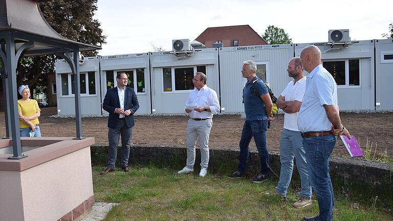 Vor der Bürgerversammlung im Mai in Wiesenfeld konnten sich Bürgerinnen und Bürger über den an den bestehenden Kindergarten angebauten Gebäudetrakt aus sechs Containern informieren. Dieser soll jetzt durch einen Anbau ersetzt werden. Vor der Bürgerversammlung im Mai in Wiesenfeld konnten sich Bürgerinnen und Bürger über den an den bestehenden Kindergarten angebauten Gebäudetrakt aus sechs Containern informieren. Dieser soll jetzt durch einen Anbau ersetzt werden.