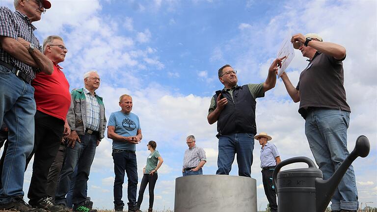 Auf dem Feldtag in Sonderhofen erläuterten Anton Lesch und Thomas Karl vom AELF an einem Versickerungsversuch, welchen Vorteil es bringt, wenn der Boden dank Zwischenfrüchten und Regenwürmern gelockert ist.