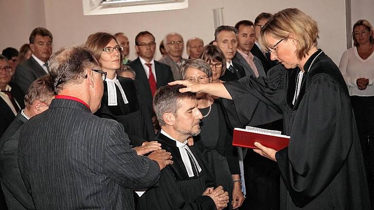 Gemeinsam mit dem Kirchenvorstand legte die Dekanin, Edda Weise, dem neuen Pfarrer von Karlstadt, Matthias Hörnig, die Hände auf. Gemeinsam mit dem Kirchenvorstand legte die Dekanin, Edda Weise, dem neuen Pfarrer von Karlstadt, Matthias Hörnig, die Hände auf.