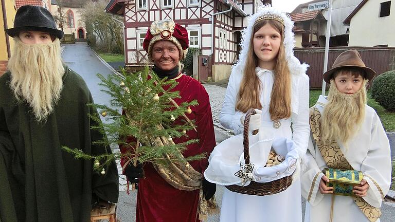 Christkindlesgehen im Jahr 2022 auf dem Dorfplatz Breitensee (von links): Leonie Gill (Hirte), Leni Bötsch (Mohr), Franziska Schneider (Christkind) und Konstantin Gütlein als Anführer. 
Foto: Josef Kleinhenz