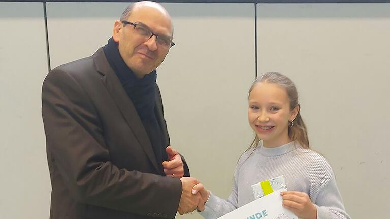 Schulleiter Ingolf John gratuliert der Siegerin Emma Hommel.