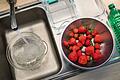 Utensilien für den Erdbeer-Lifehack in einer Küche       -  Man braucht: Erdbeeren, Wasser, Essig, Papiertücher und ein flaches Behältnis.