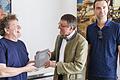 Autor Harald Knobling (Mitte) übergibt dem VKU-Vorsitzenden Andi Schmitt (links) die druckfrische Chronik über 100 Jahre VKU. Rechts im Bild: Verleger Daniel Seger.