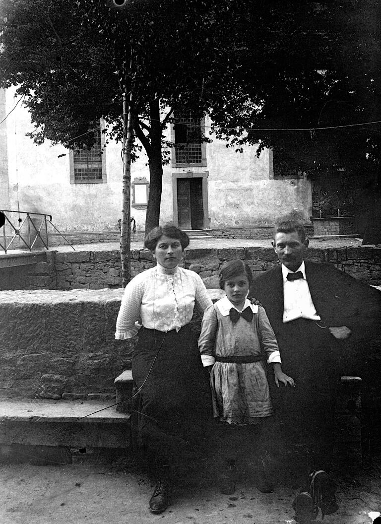 Familie am Schafbach: Dieses Bild von einem Elternpaar mit seiner Tochter wurde in Goßmannsdorf aufgenommen. Im Hintergrund ist die alte Fußgängerbrücke und die Kirche zu sehen. Familie am Schafbach: Dieses Bild von einem Elternpaar mit seiner Tochter wurde in Goßmannsdorf aufgenommen. Im Hintergrund ist die alte Fußgängerbrücke und die Kirche zu sehen.