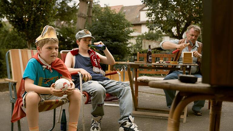 TV-Ausblick - Das Erste 'Ein Mann seiner Klasse'       -  Christian (Camille Loup Moltzen, li.) und sein Bruder Benny (Len Blankenberg, mi.) sind genau wie der Rest der Familie glühende Verehrer des 1. FC Kaiserslautern.
